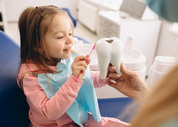 Child using toothbrush on toy