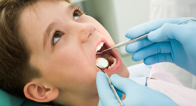 A child getting mouth examined by dentist.